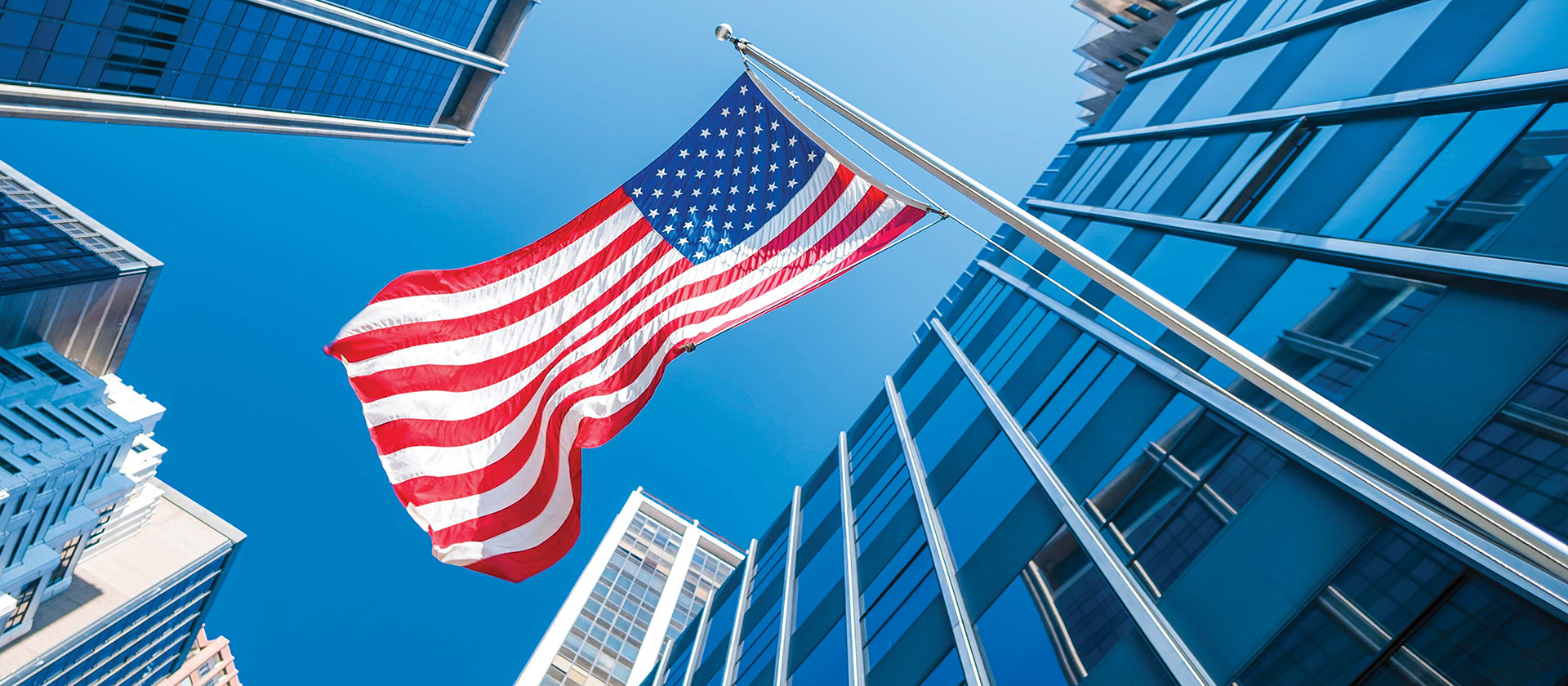 American flag hanging in city skyline