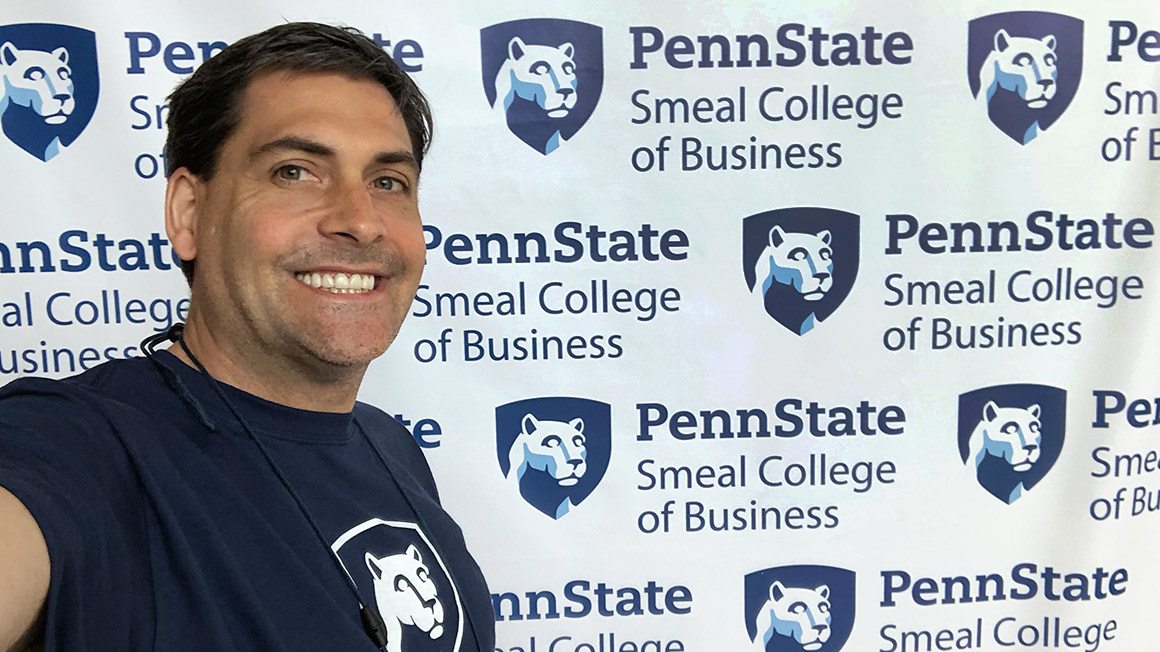 Bussey takes a selfie in front of a Penn State backdrop.