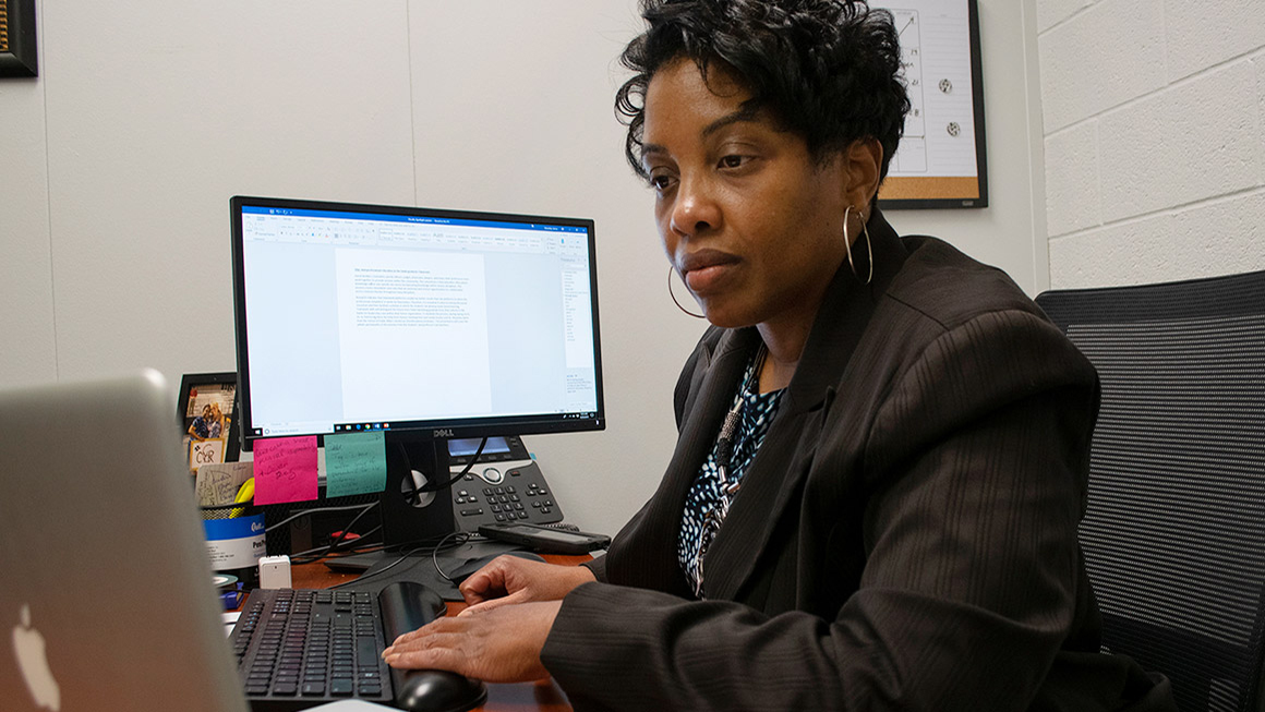 Shauntey James is typing on her computer in her office.