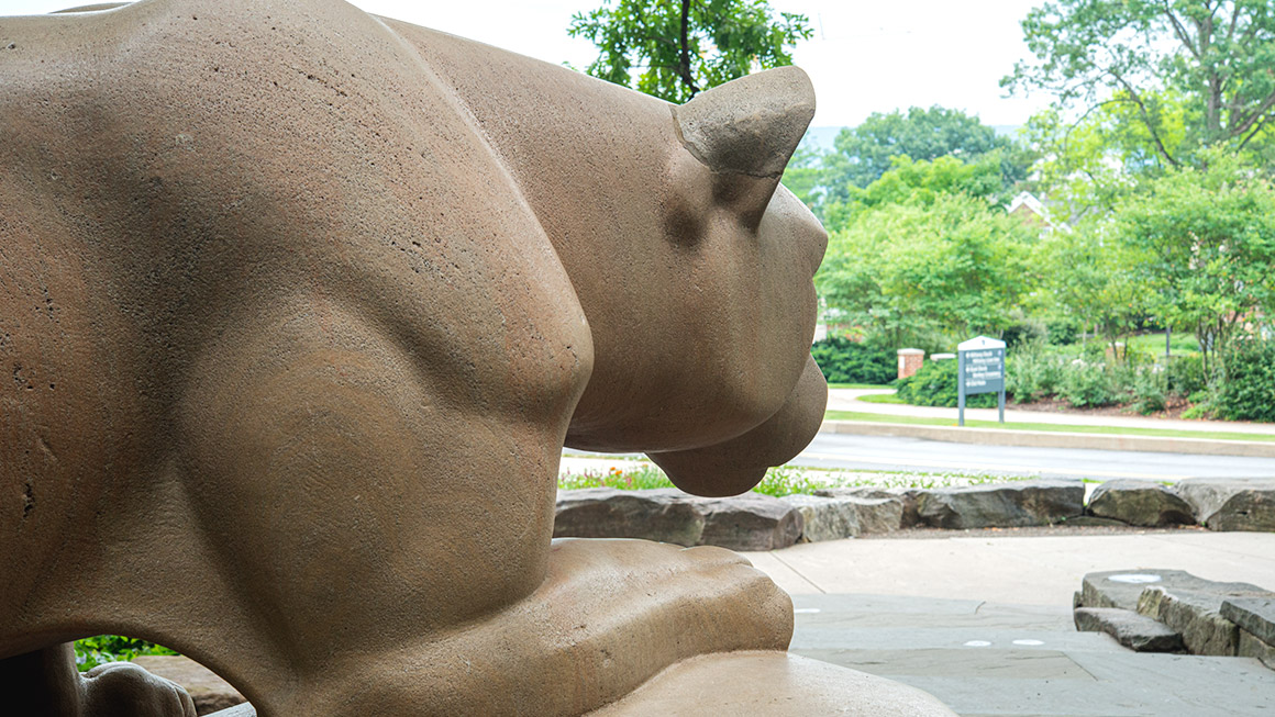 A photograph shows a shoulder of the Nittany Lion shrine at the University Park campus.