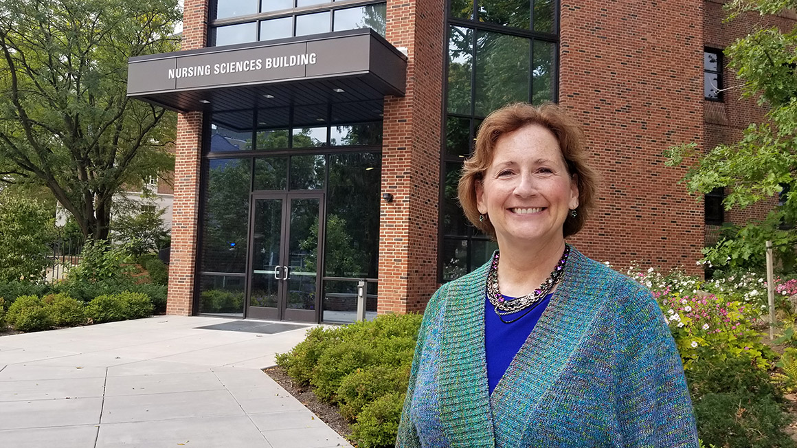 Kelly Wolgast from the Penn College of Nursing is pictured with the entrance to the Nursing Sciences Building in the background