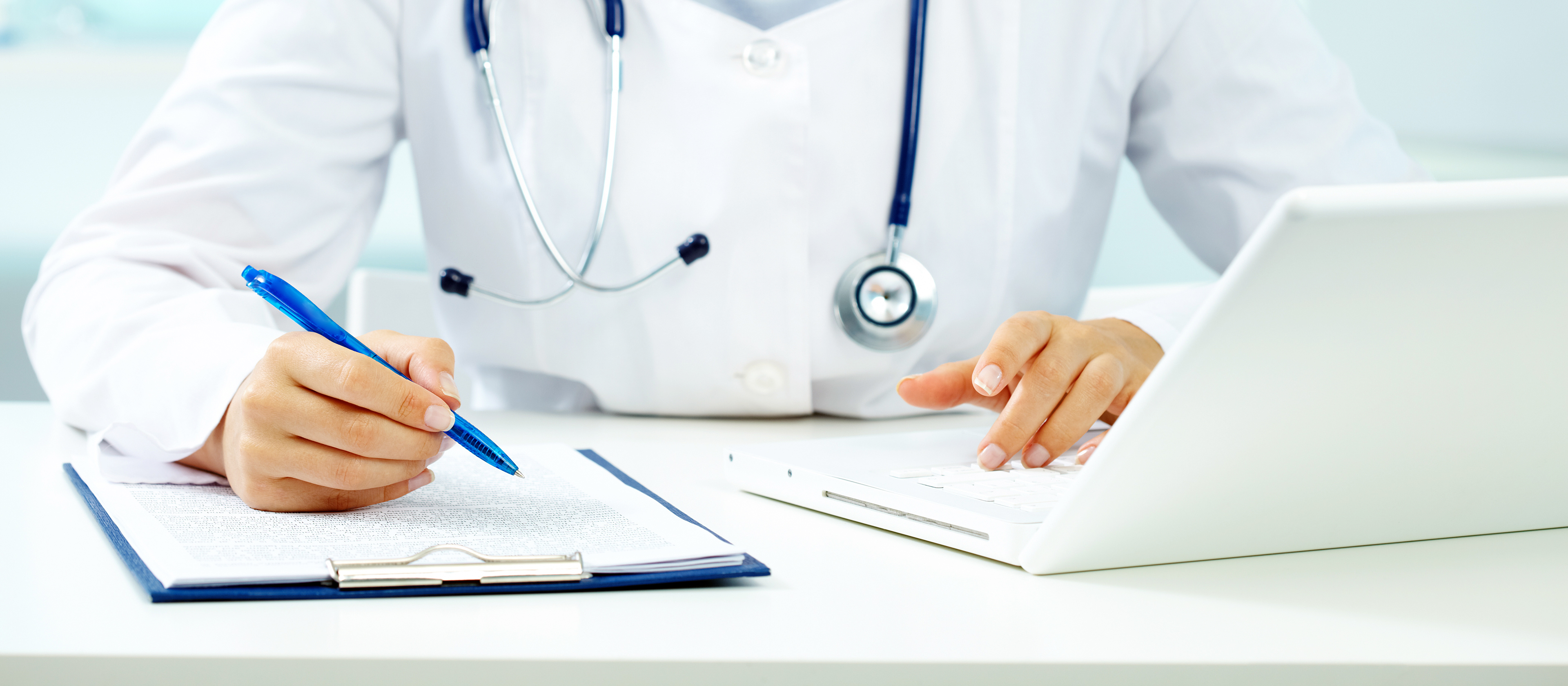 Nurse working on computer and taking notes