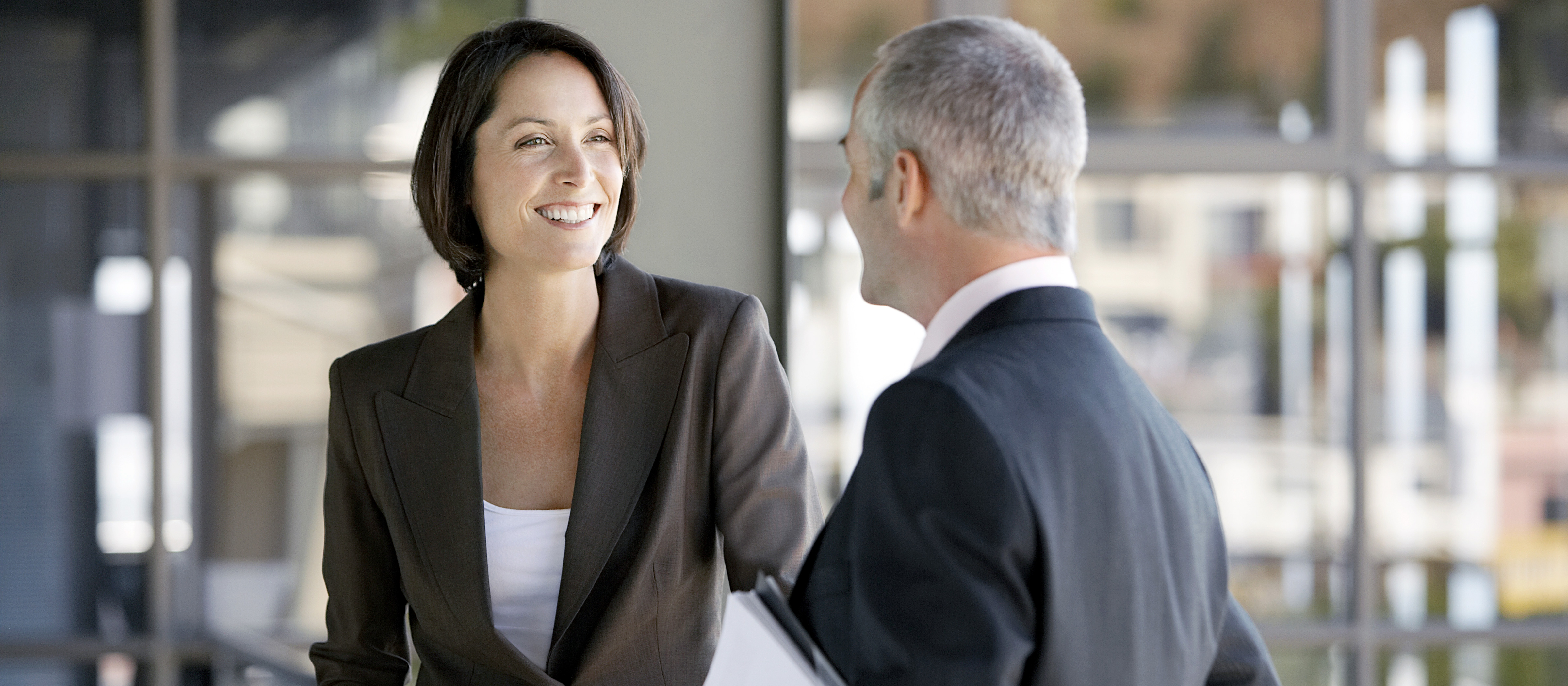 Two business professionals talking outside of a meeting