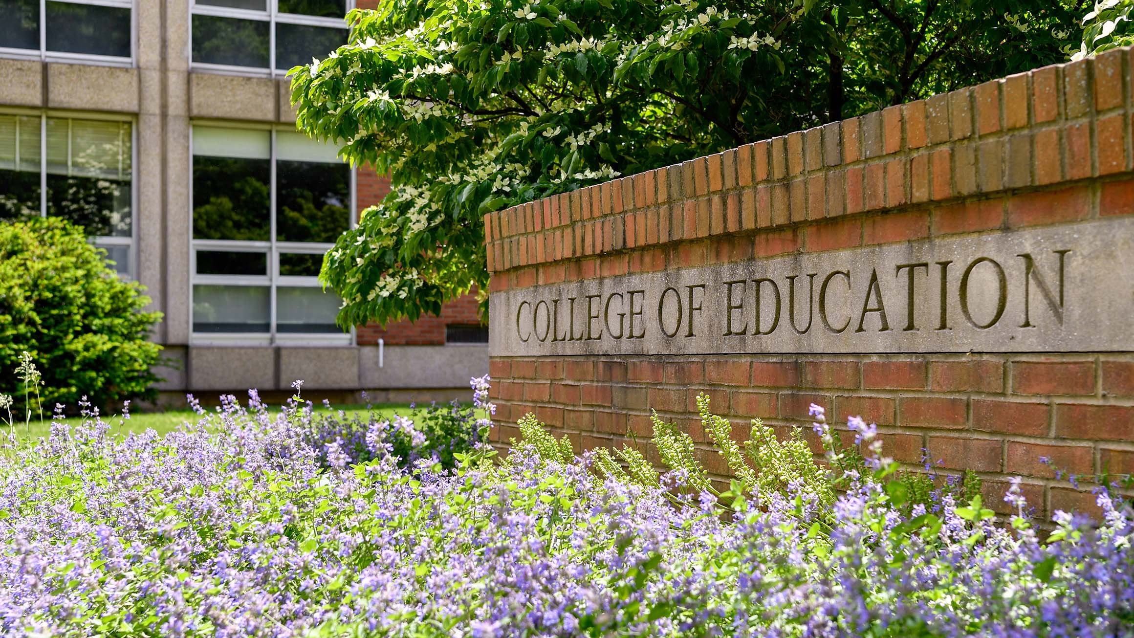 The name of the College of Education at Penn State is displayed on a brick wall.