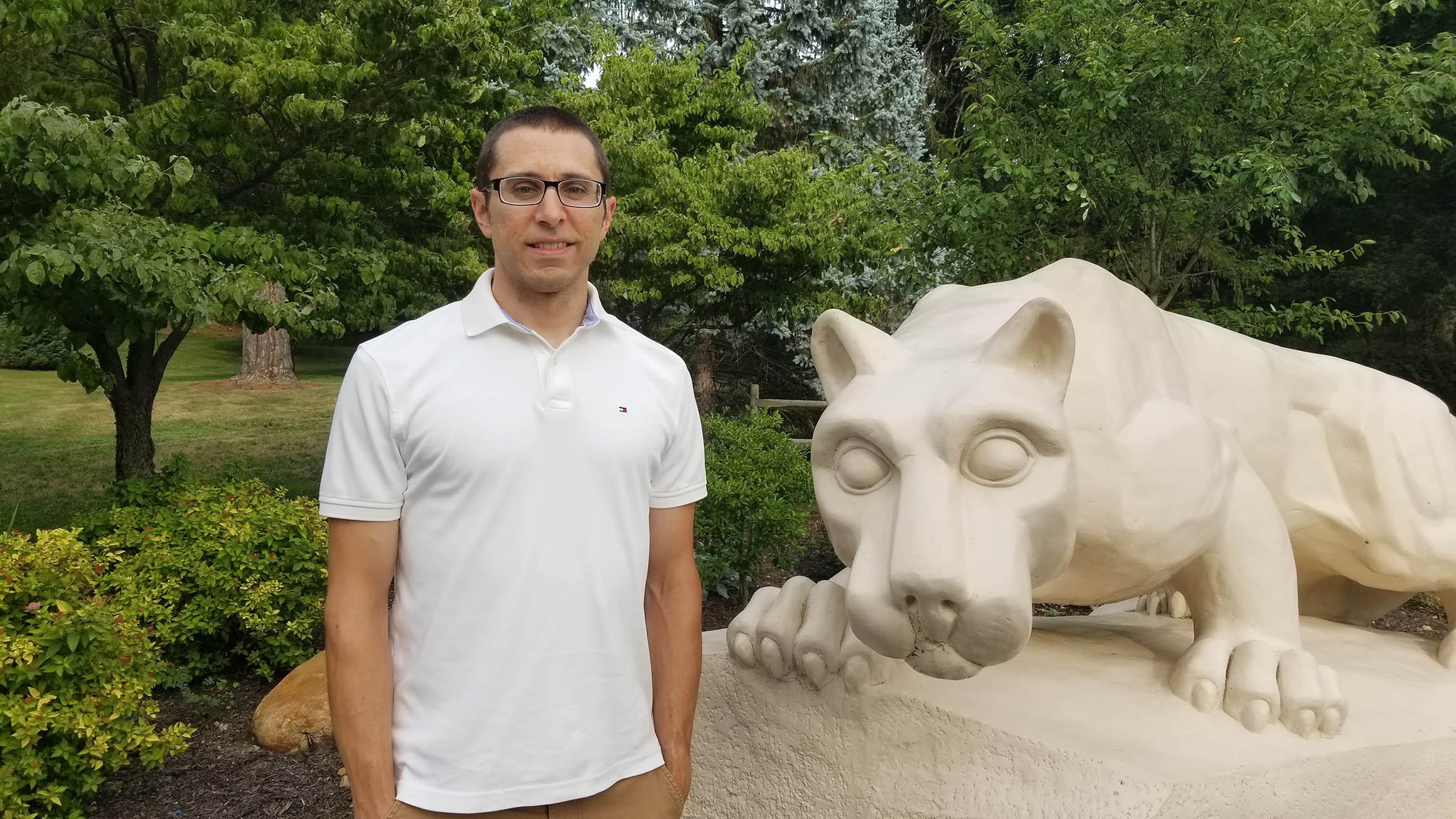 Marcus Rauhut stands to the left of a statue of the Nittany Lion Shrine at the Mont Alto campus.