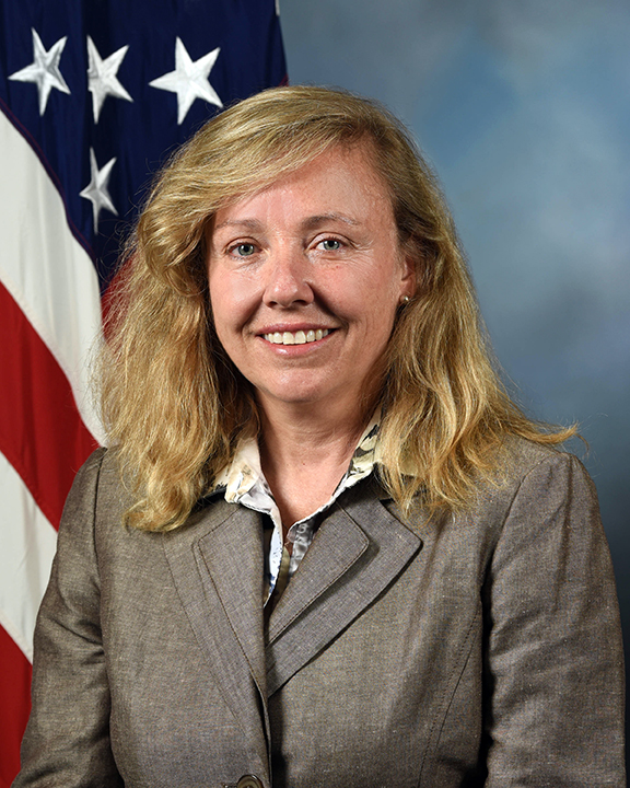 Linda Wackerman is shown with an American flag in the background