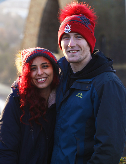 man and woman standing in front of a bridge