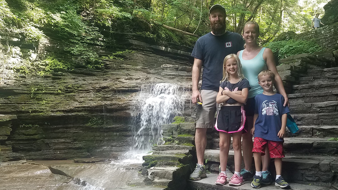 Family posing in ront of a waterfall