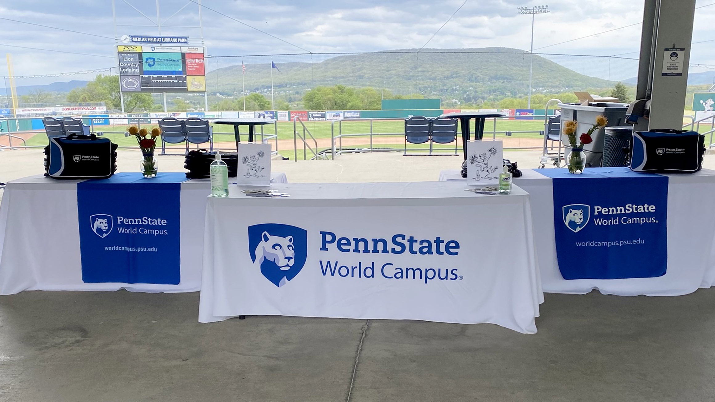 a penn state world campus tablecloth on a booth with a mountain in the background