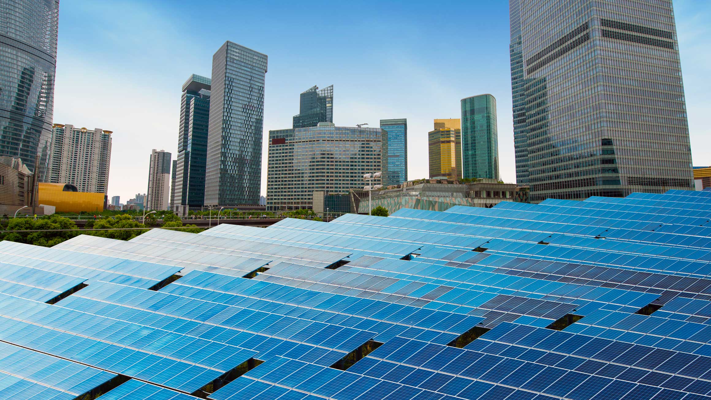 Photo of solar panels in front of cityscape.