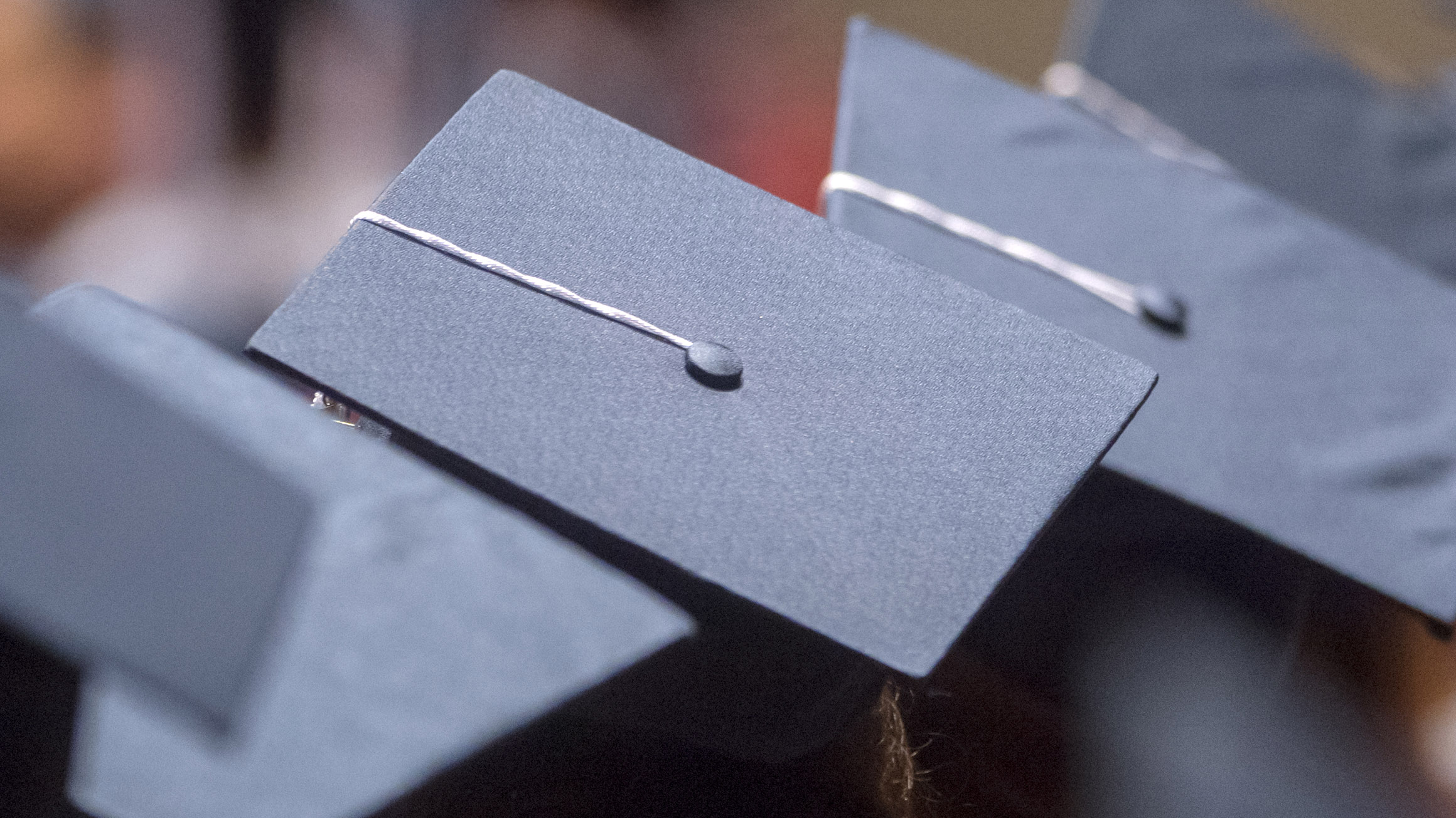 2 graduation caps are shown in a graduation ceremony