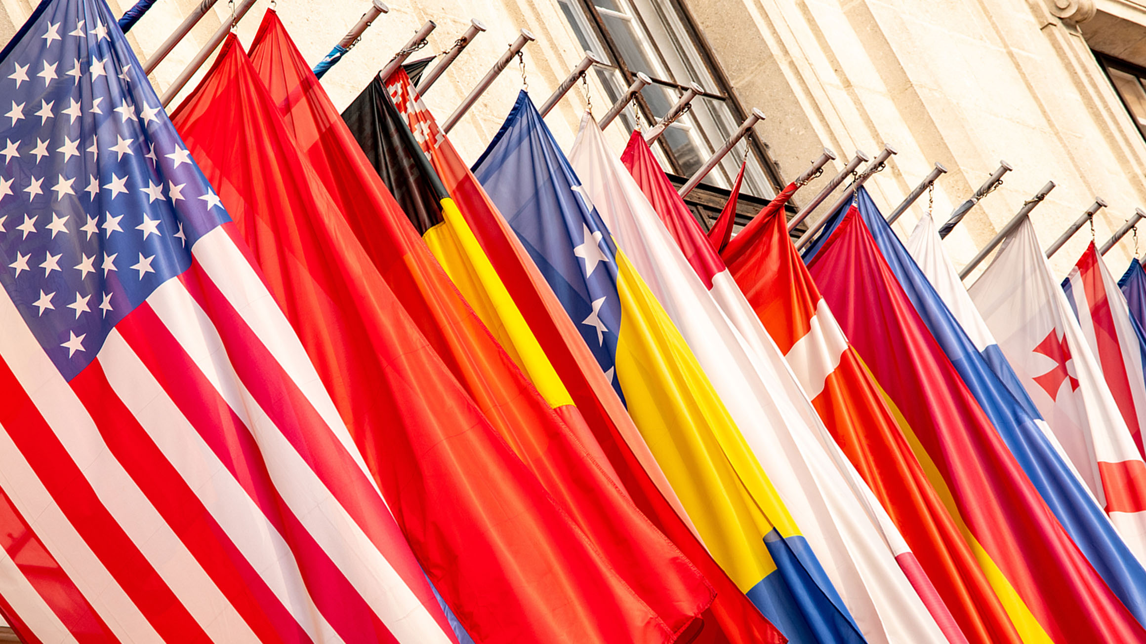 several flags are shown hanging outside windows on a building