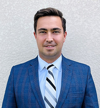 A headshot Matt Mullins wearing a suit and tie 