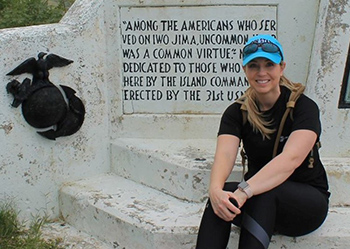 Lisa Pritchard sits on a wall with a quote written on it