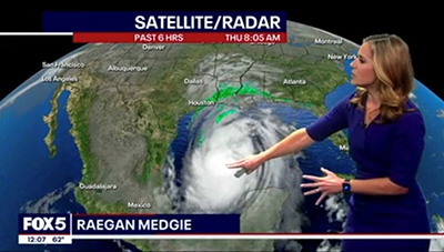 Raegan Medgie stands in front of a satellite weather map.