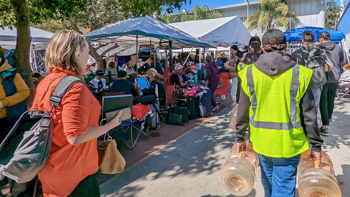 People gather underneath temporary canopies.