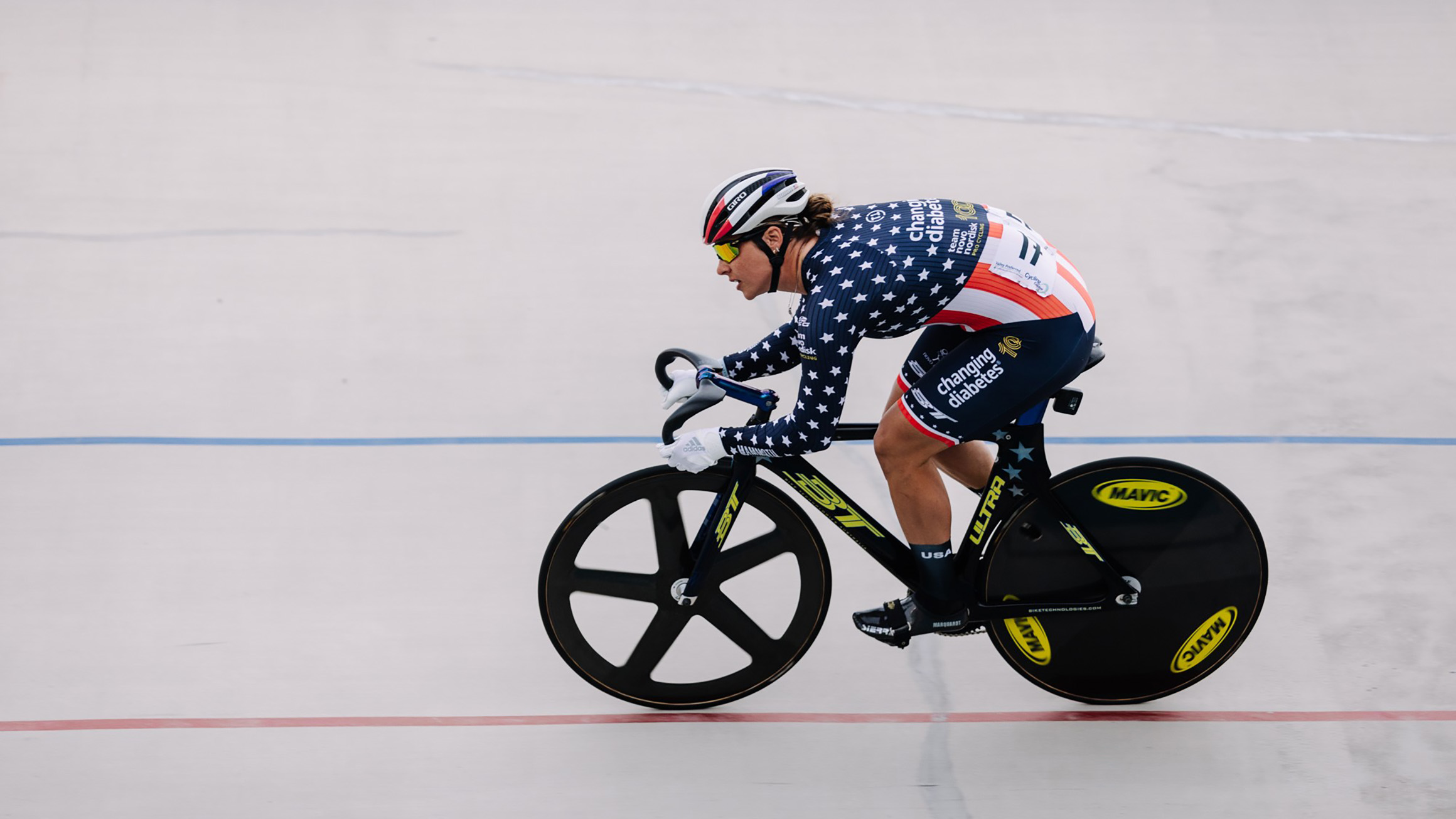 A woman on a bicycle races down a track.