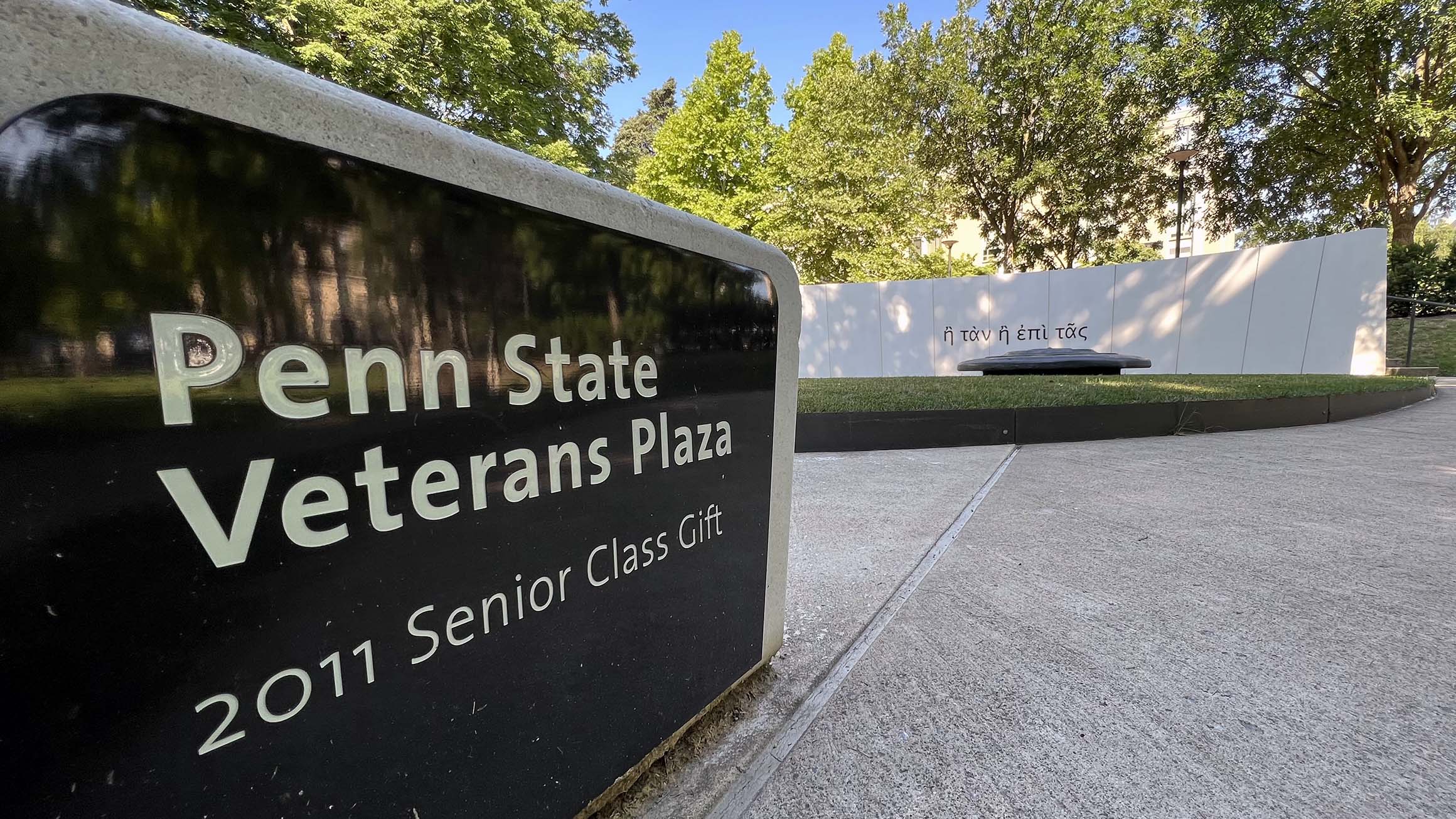 A sign reading Penn State Veterans Plaza, 2011 senior class gift in the foreground with the plaza in the background