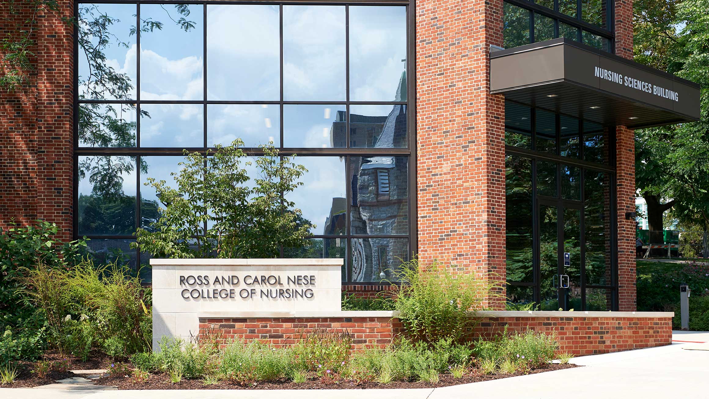 The Nursing Sciences Building is shown with a sign for the Ross and Carol Nese College of Nursing in front of it
