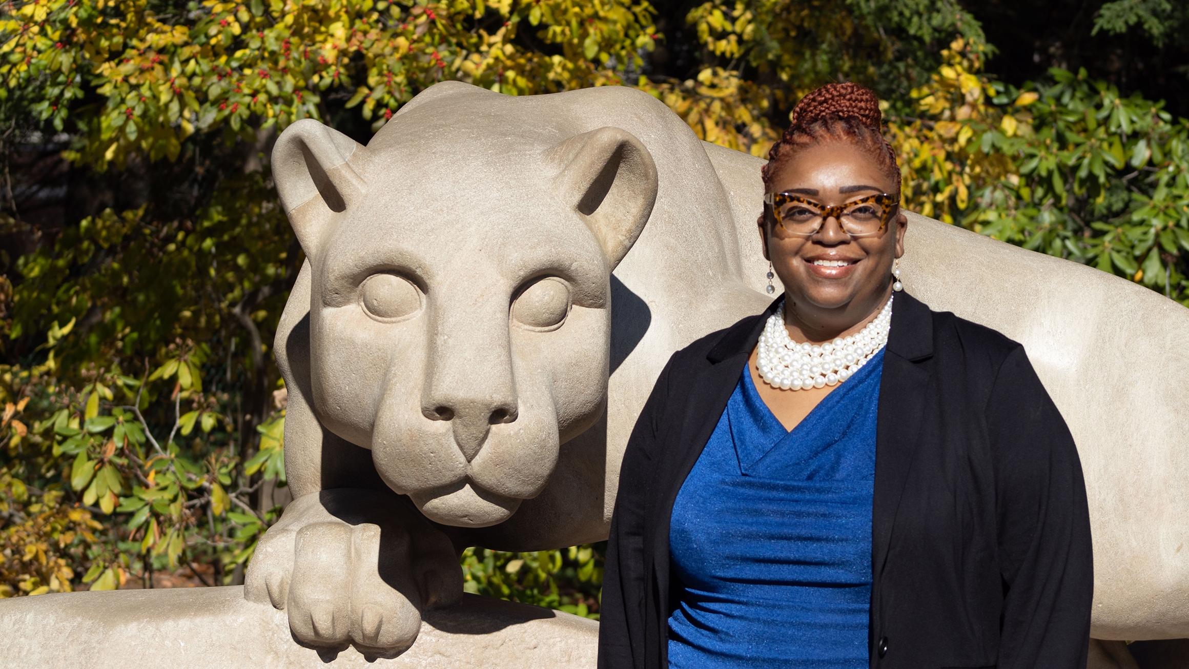 Dionne R. Wiggins poses in front of the Lion Shrine at Penn State University Park.