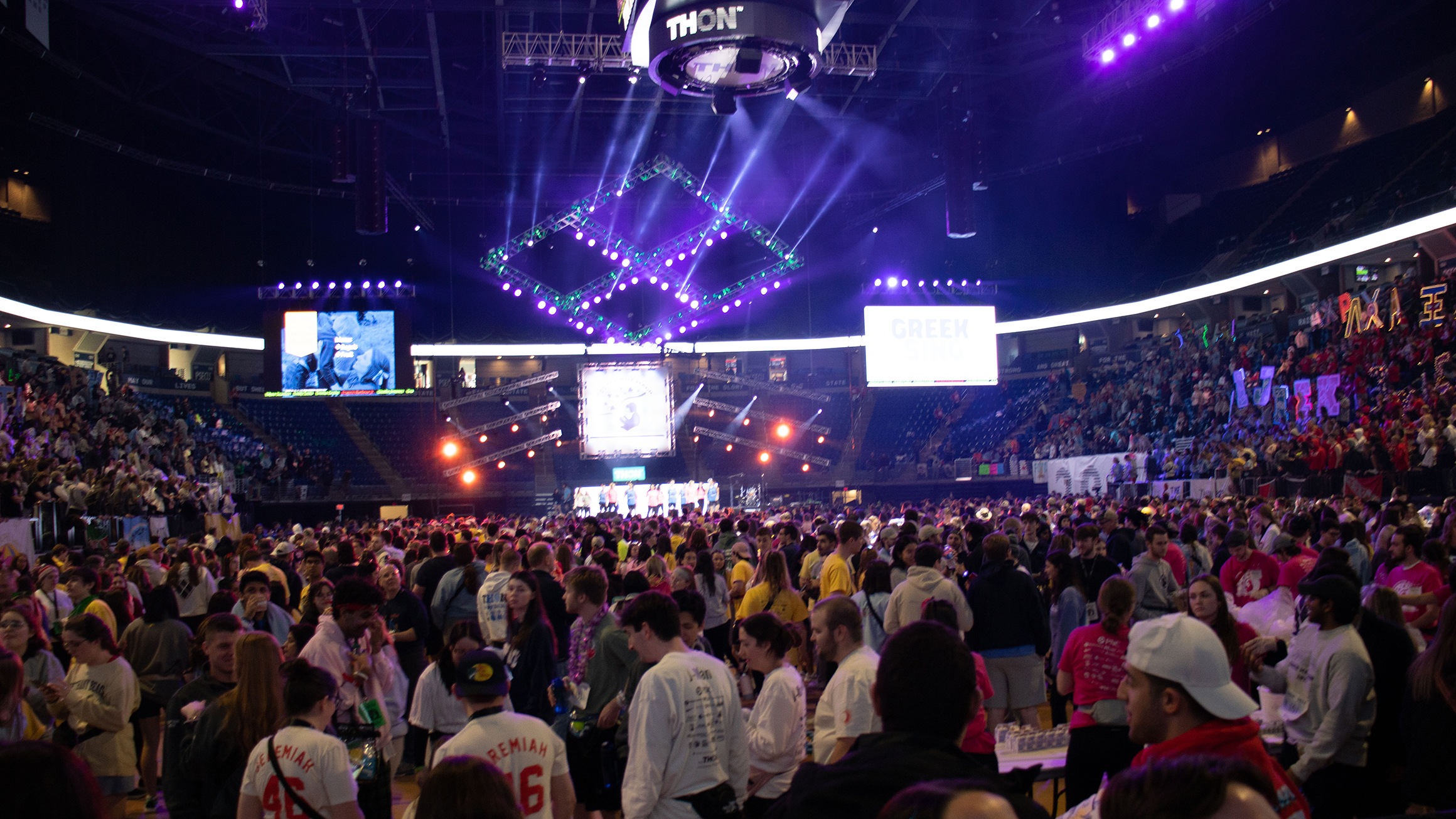 A crowd of people gather in an indoor arena.