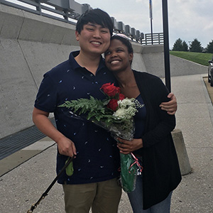 Andy Park hugs his wife, who is holding flowers.