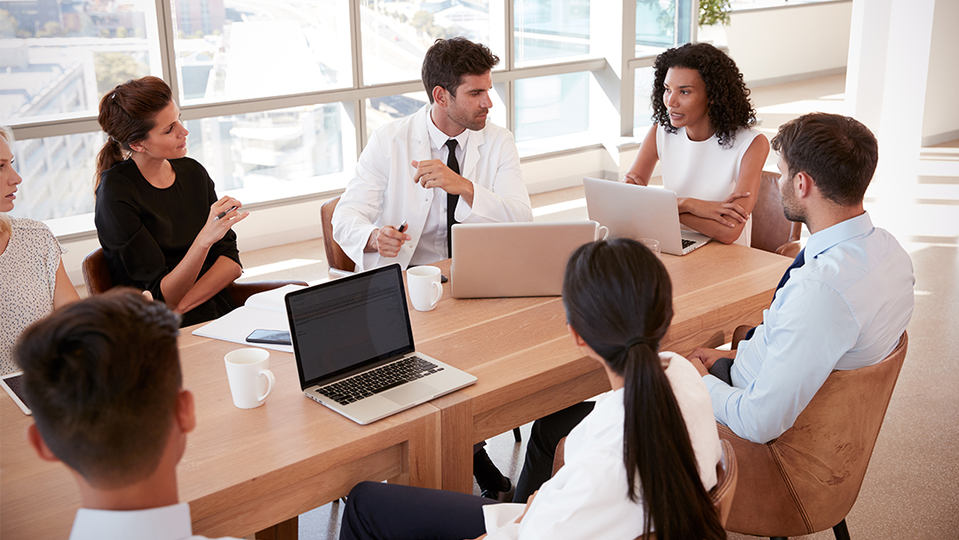 A group of health care professionals and administrators in a business meeting