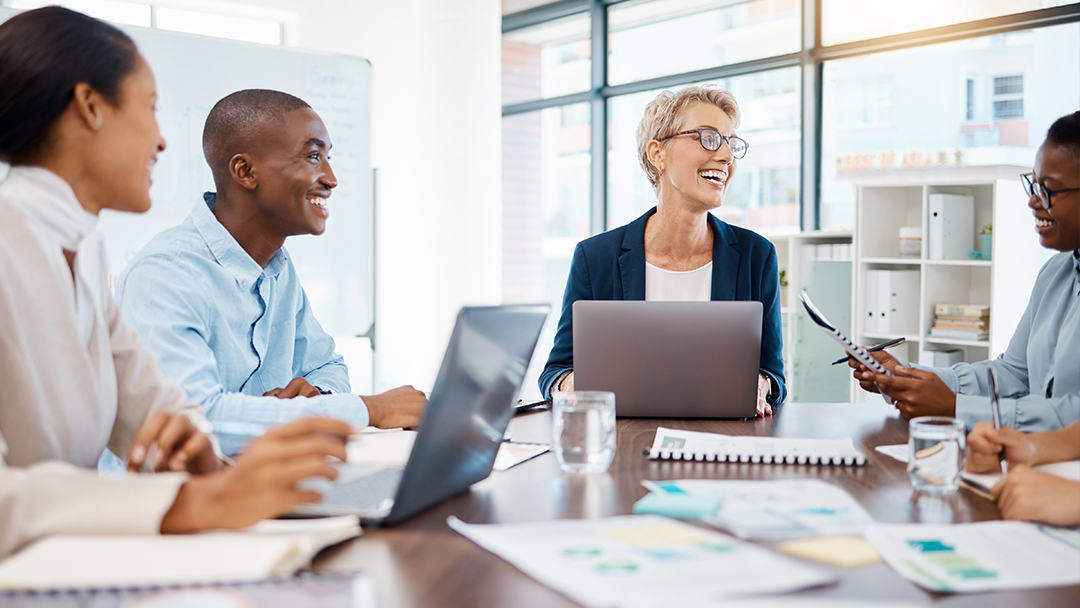 A group of business professionals collaborating and laughing in a meeting