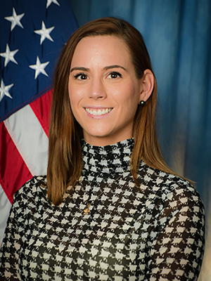 A headshot of Rebekah Everett with an American flag in the background