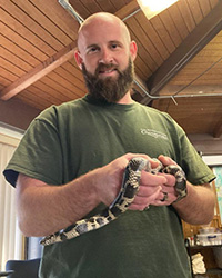 Zach Winslow poses with a snake around his waist