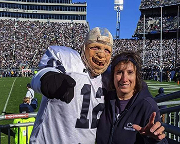 Theresa Tama stands next to a football fan at Beaver Stadium.