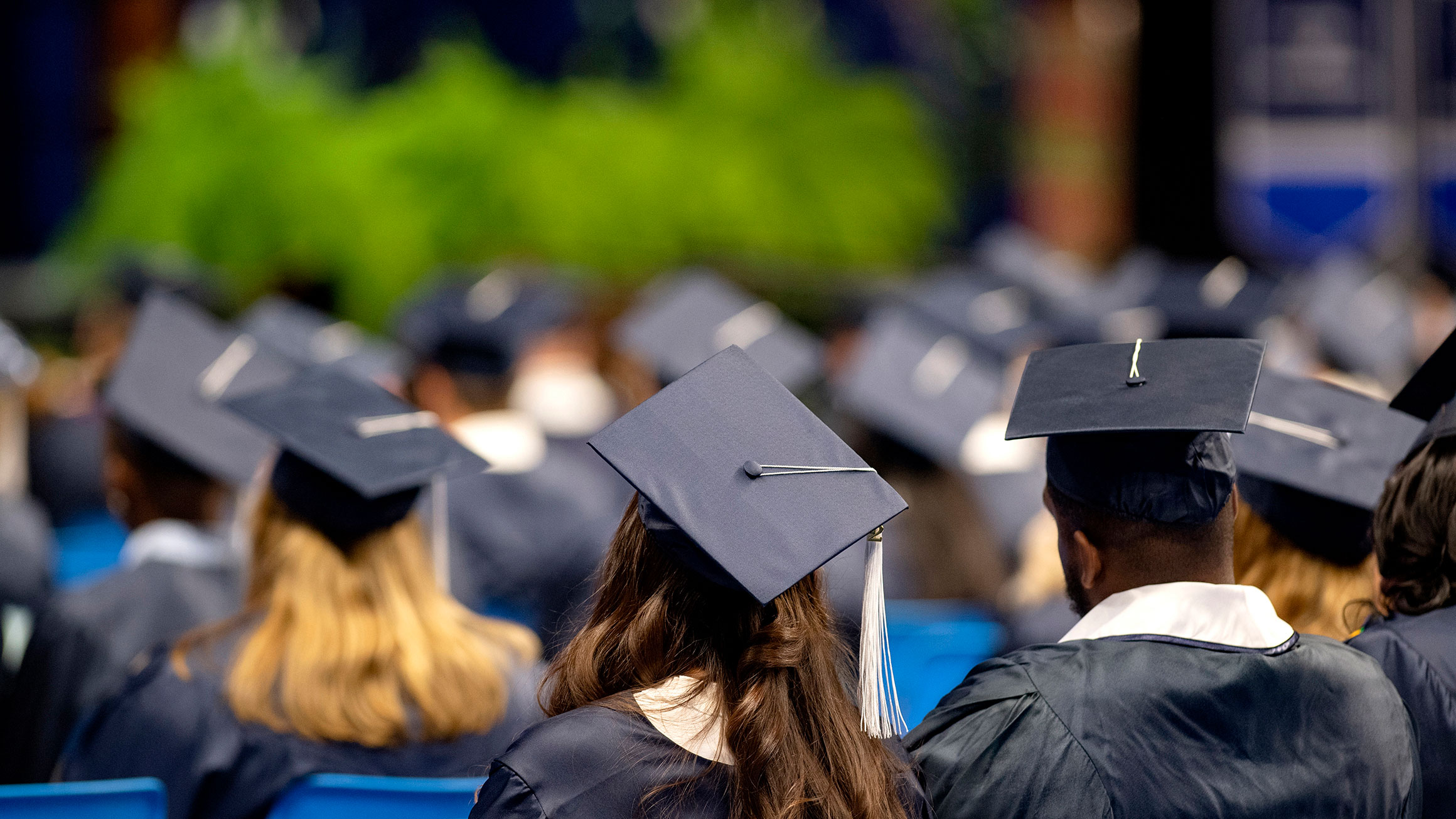 A group of graduates sit during a commencement ceremony.