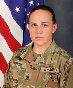 Dana Richmond wears her military uniform with the U.S. flag in the background.