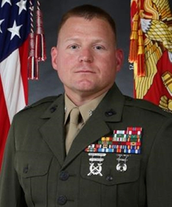 Randy Nickel is in his uniform with the flag of the U.S. and the Marine Corps flanking him in the background