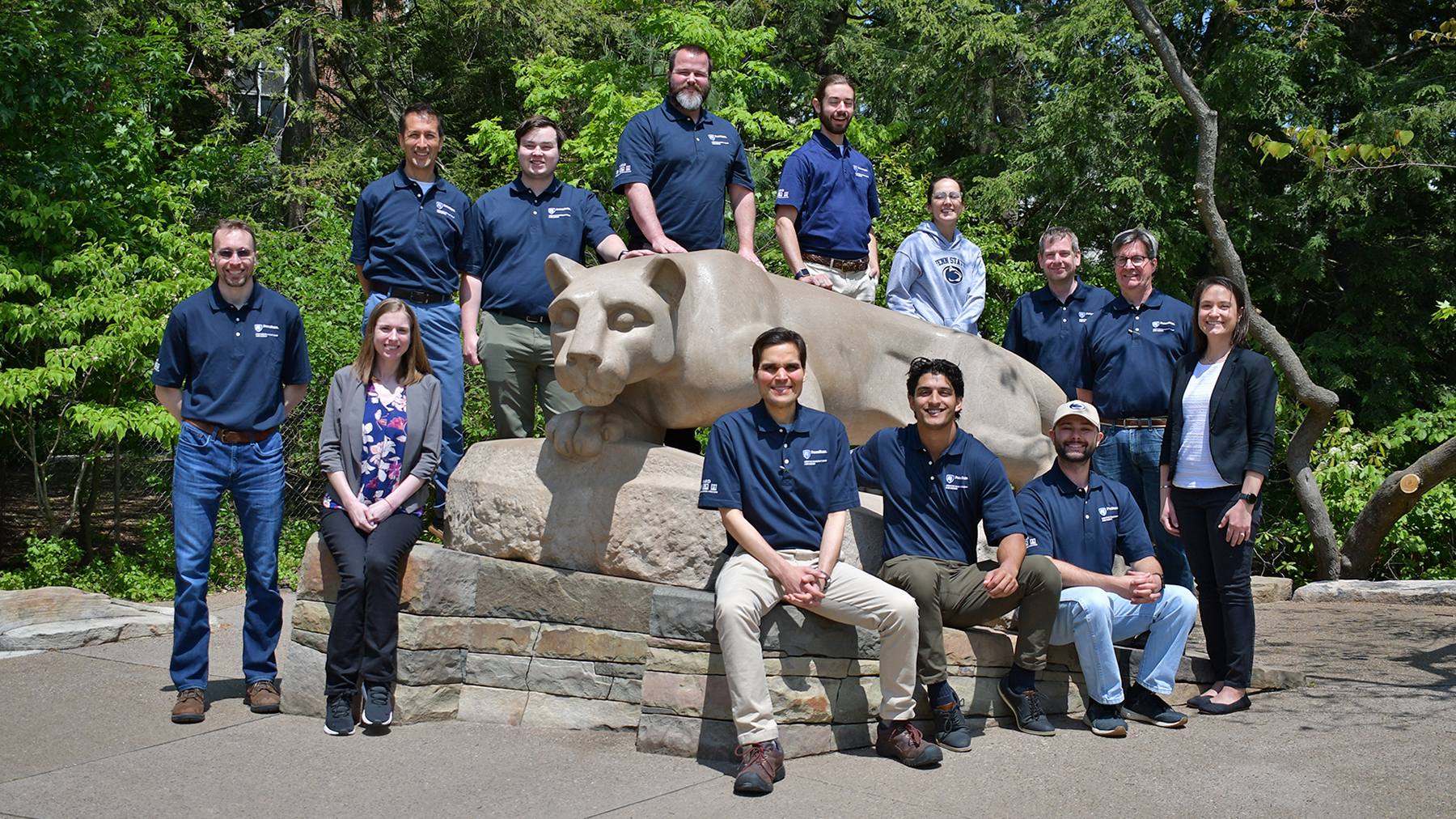 A group of people pose at the Nittany Lion Shrine.