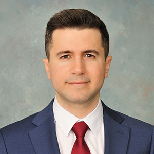 a headshot of mauricio dell wearing a suit and tie