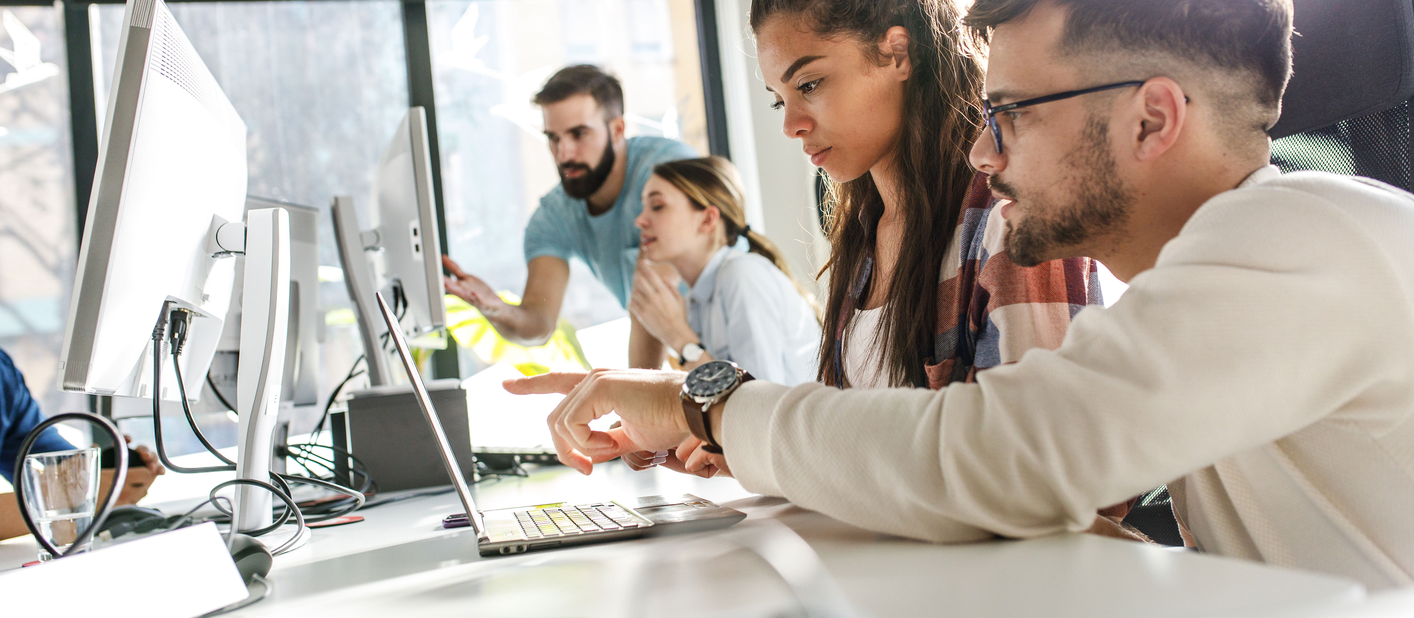 Two pairs of people working at computers