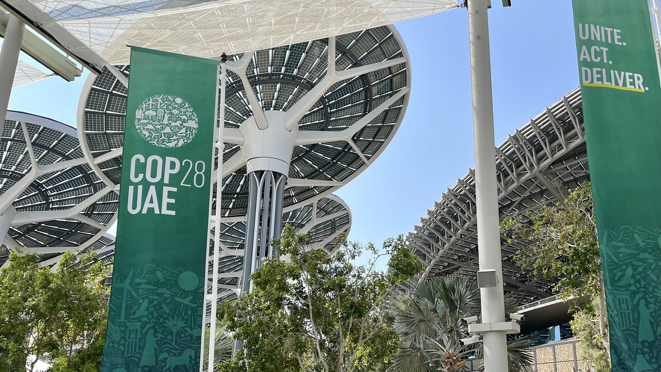 The name of COP28 is on a banner hanging from the entrance at the conference