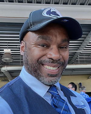A man wearing a Penn State had poses for a photo.