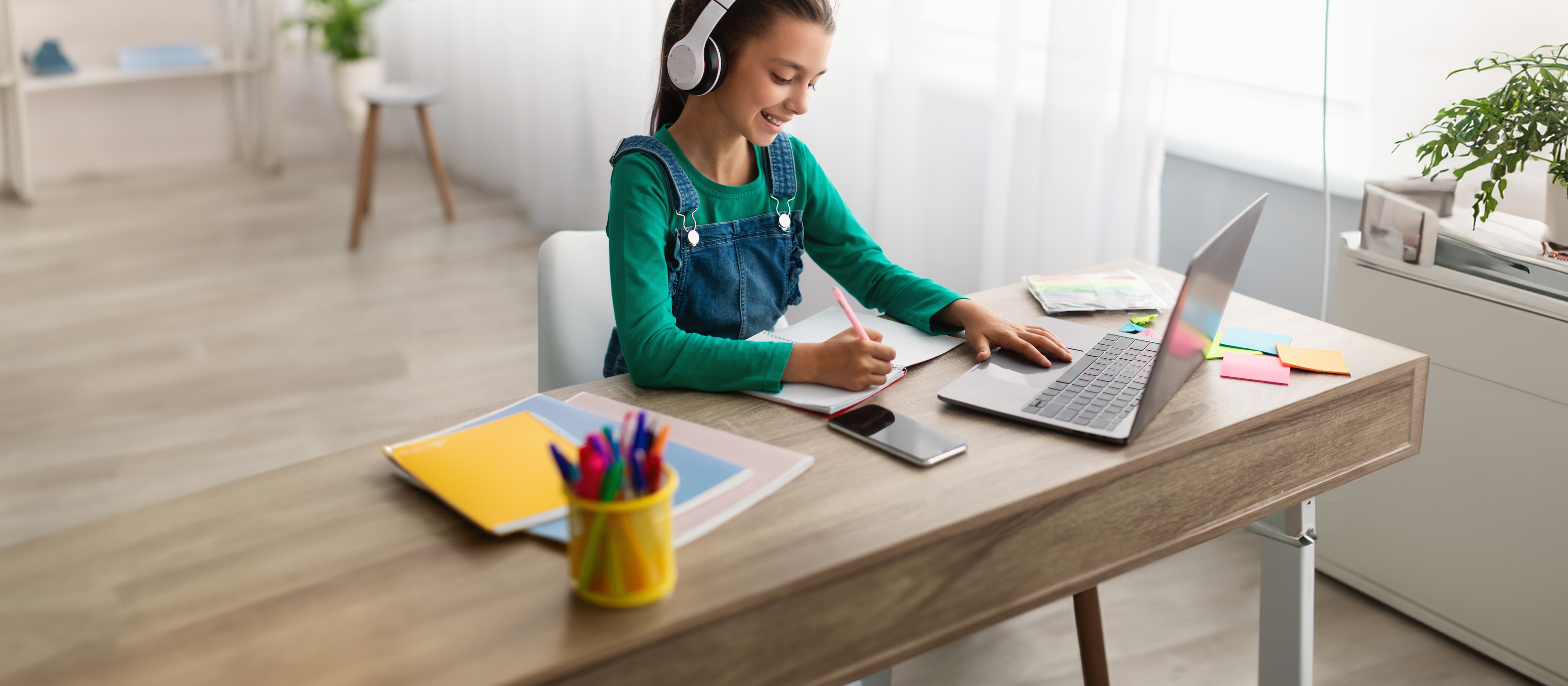 child sitting at a desk looking at a laptop