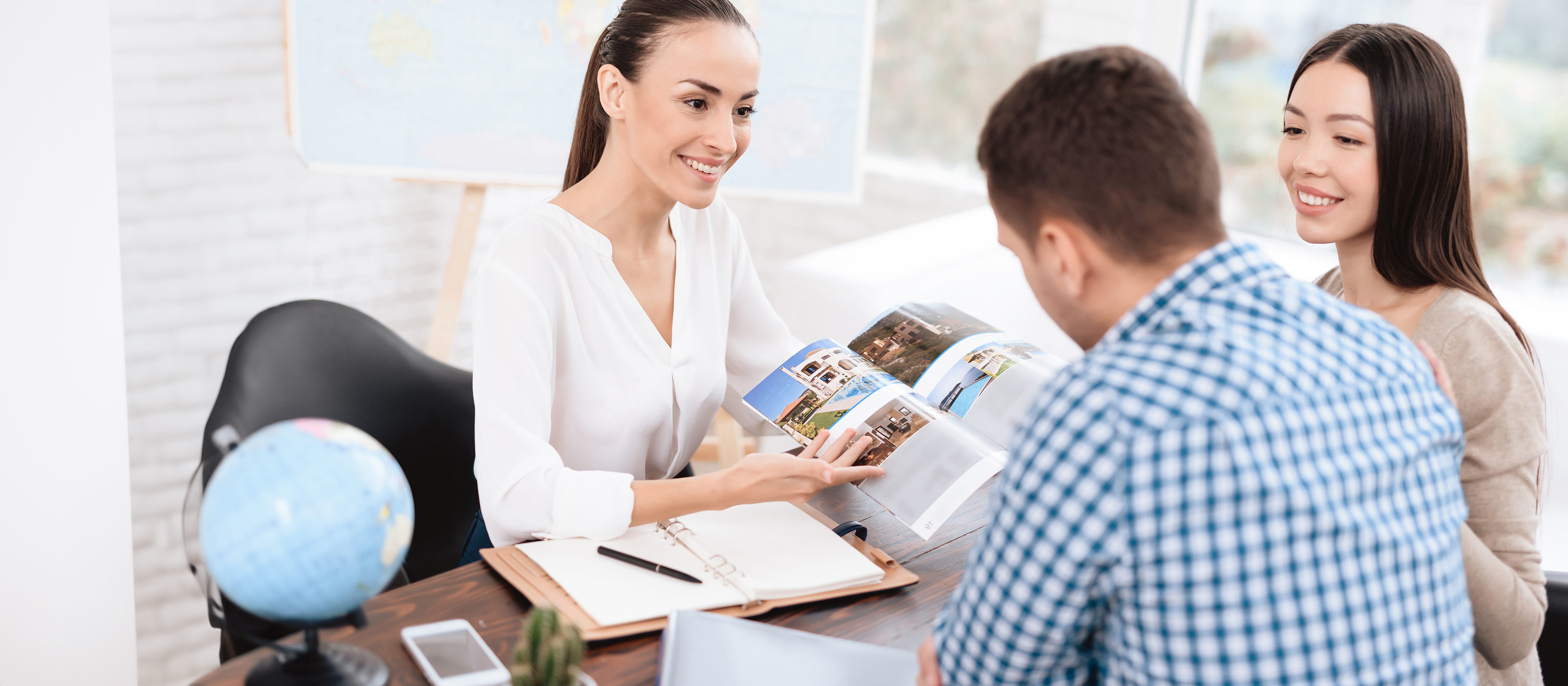 tourism professional speaking to a couple sitting at a desk