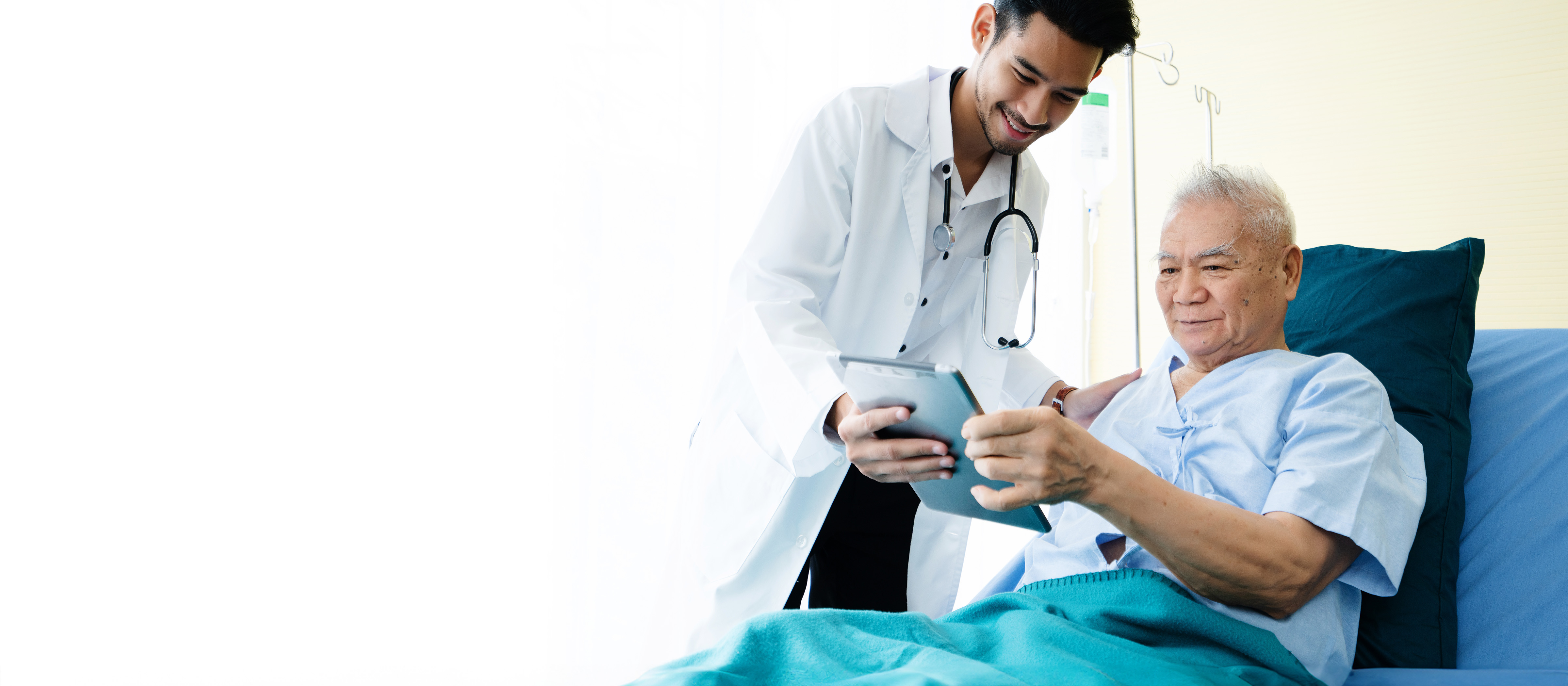 doctor speaking to a man laying in a hospital bed 