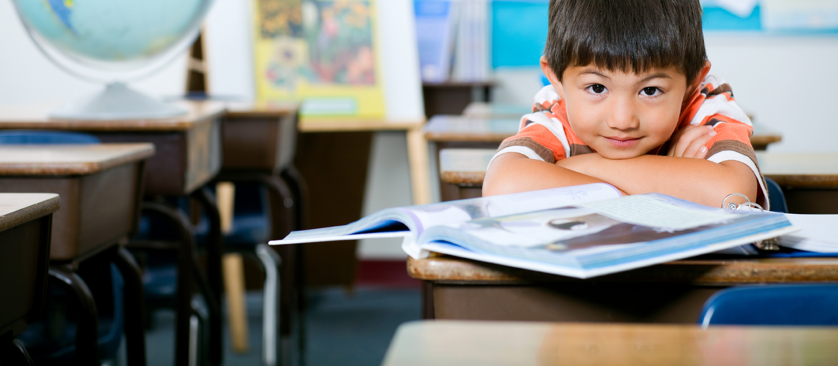 child sitting at a desk in a classroom