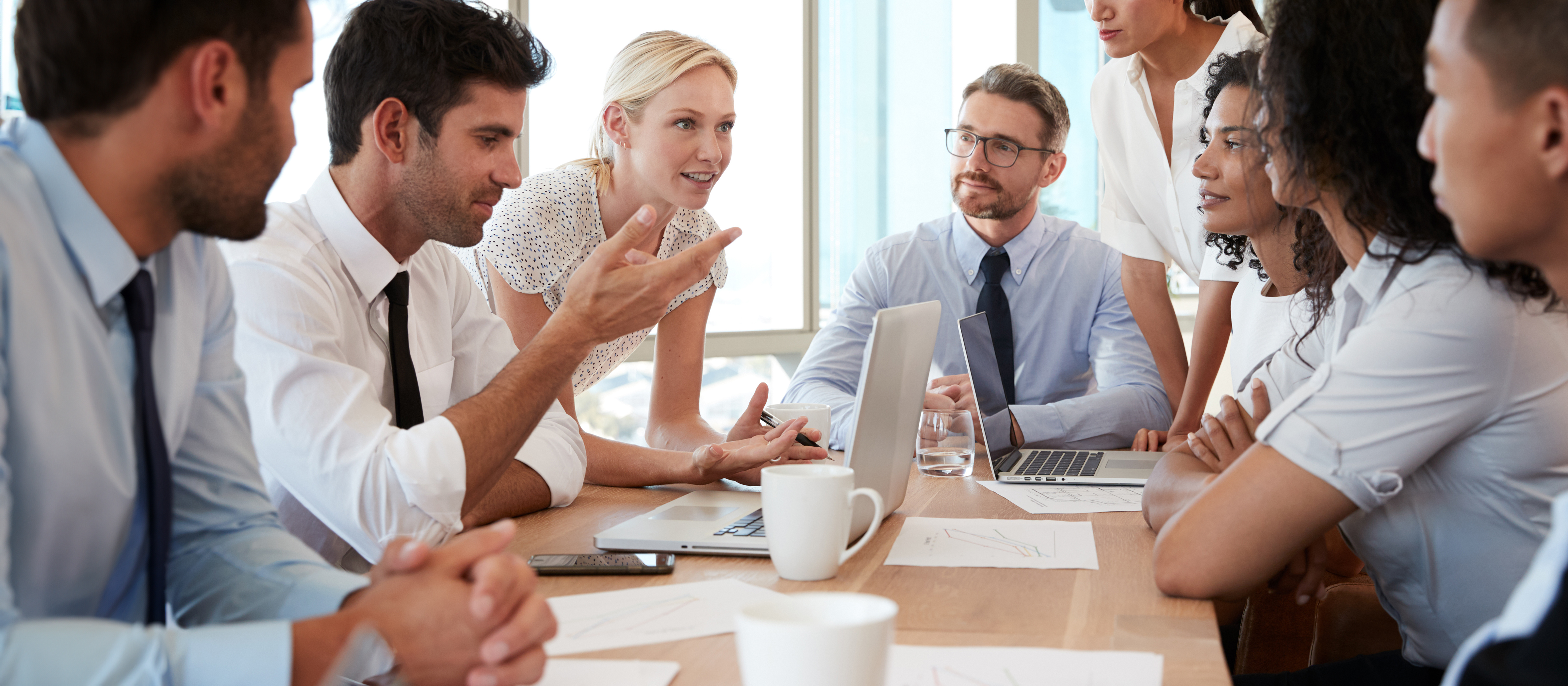 group of professionals sitting at a conference table talking to each other