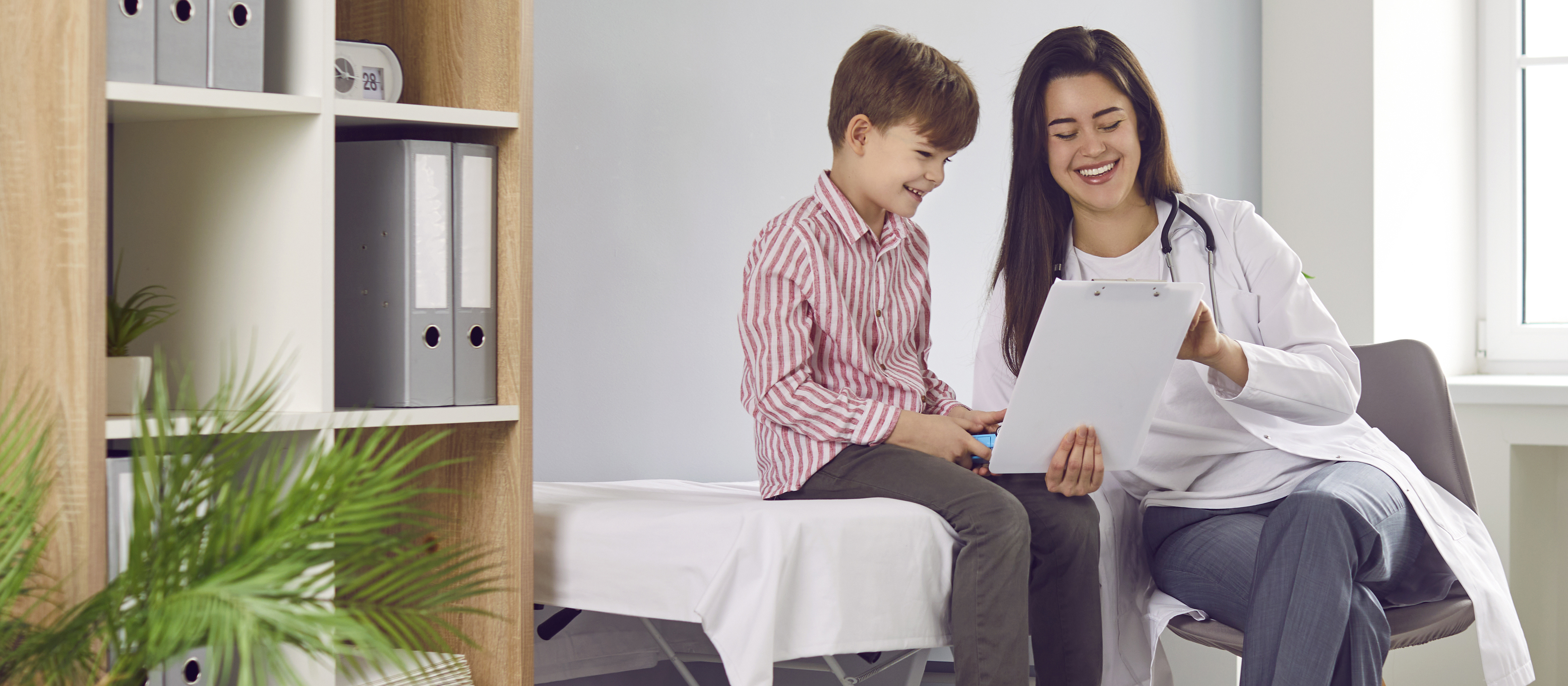 nurse and child looking at a clipboard in an office