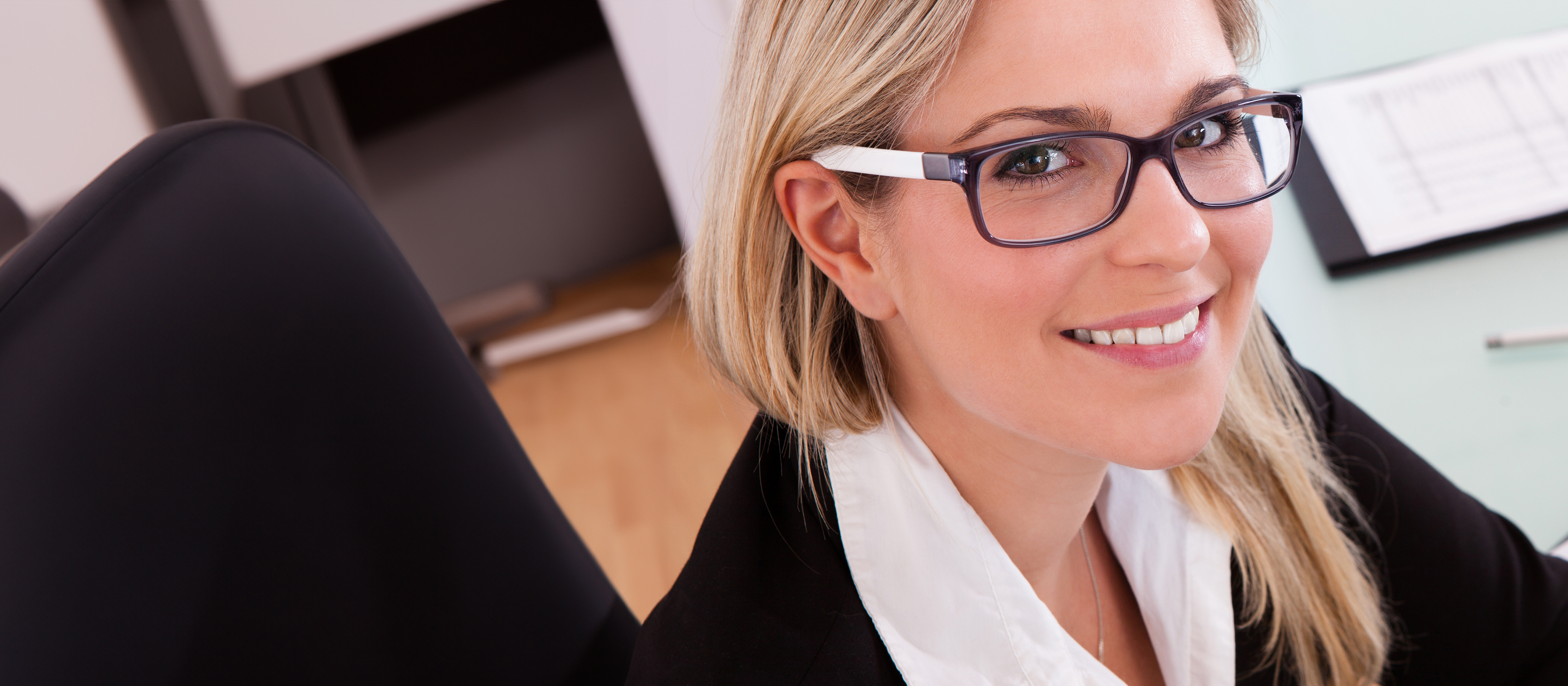 accountant sitting a desk and smiling at the camera