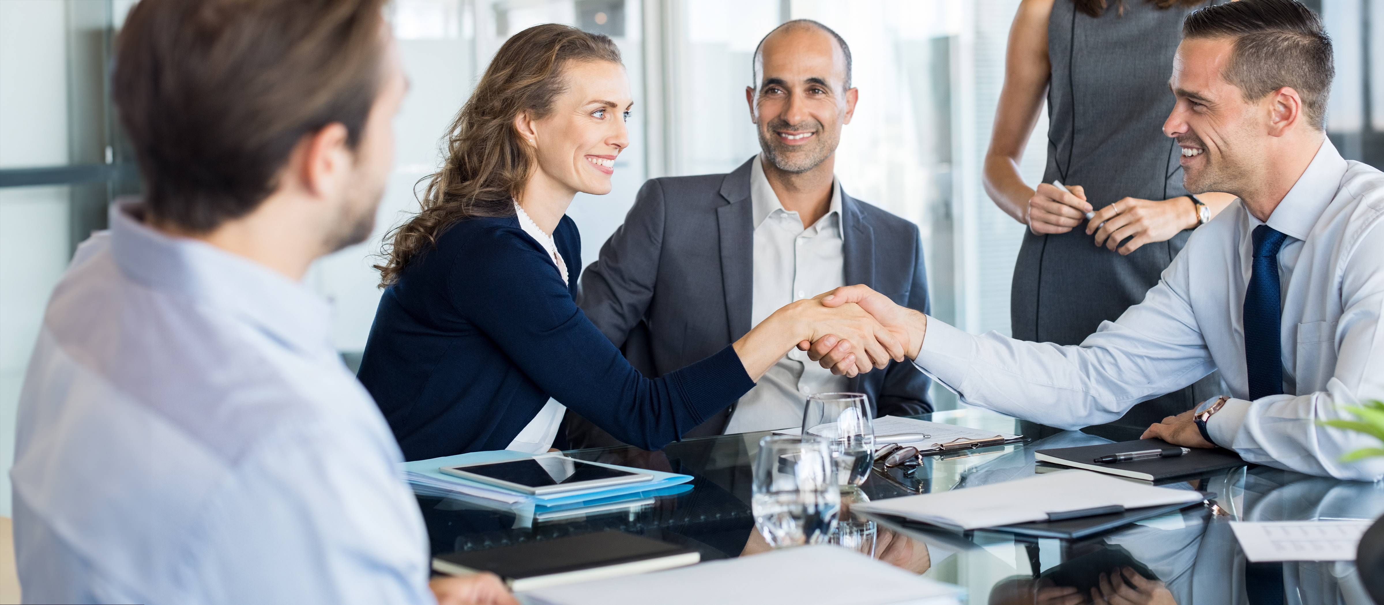 professionals shaking hands over a conference room table