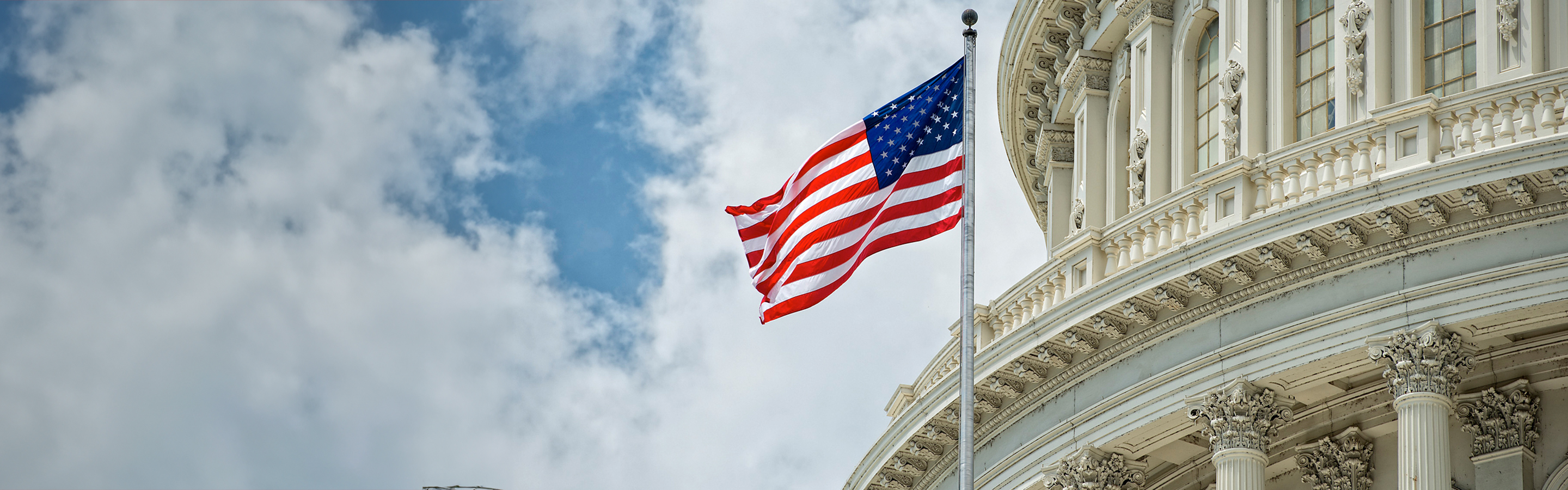 flag on a flag pole in front of a white building 