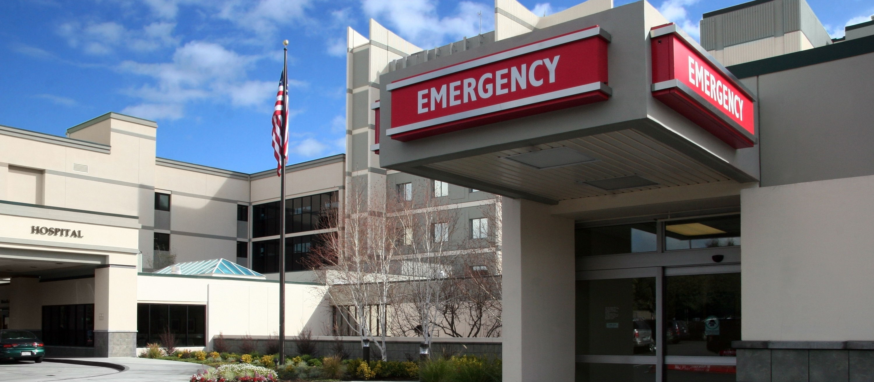 exterior of a hospital with a sign that reads EMERGENCY