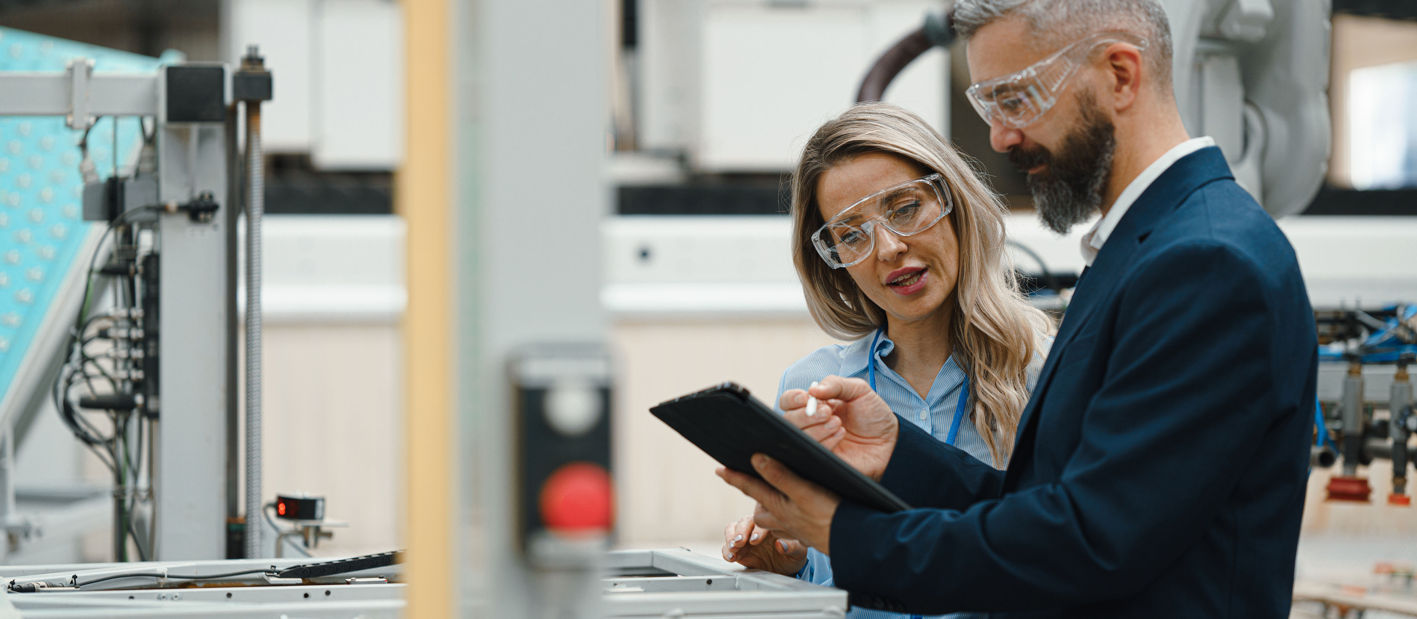 Two quality management professionals looking at a clipboard 